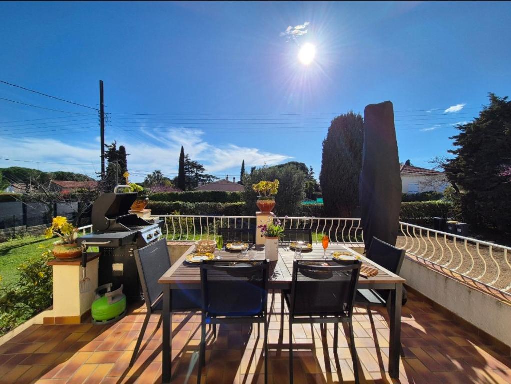 un patio avec une table et des chaises sur une terrasse dans l'établissement Maison familliale, vaste jardin proche mer et centre ville, à Bandol