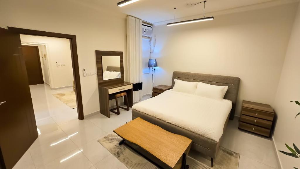 a bedroom with a bed and a mirror and a table at شقق سكنية مفروشة فاخرة - مكة الشرائع in Ash Sharāʼi‘