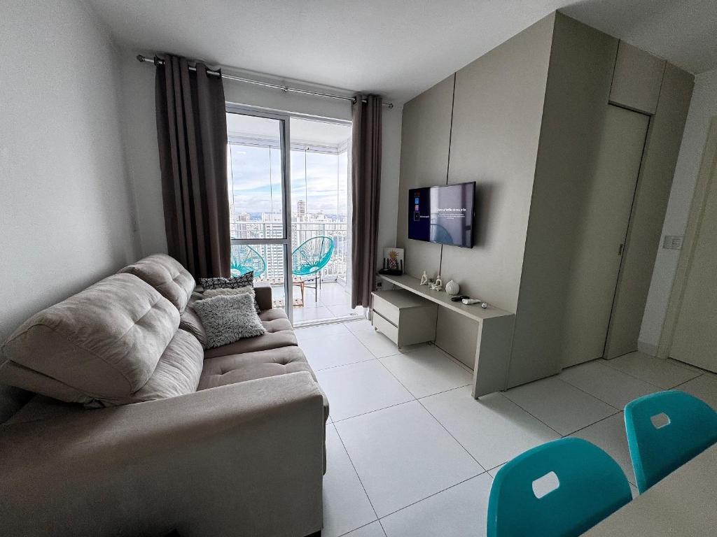 a living room with a couch and a tv at Walk Bueno, Próximo Parque Vaca Brava e Goiânia Shopping. in Goiânia