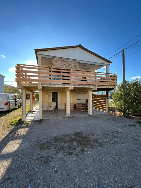 une maison avec une terrasse sur le côté dans l'établissement Gruissan chalet authentique 50m de la plage, à Gruissan