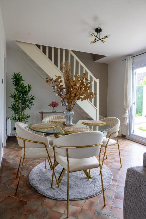 une salle à manger avec une table et des chaises dans l'établissement Maison près de Disneyland, à Saint-Germain-sur-Morin