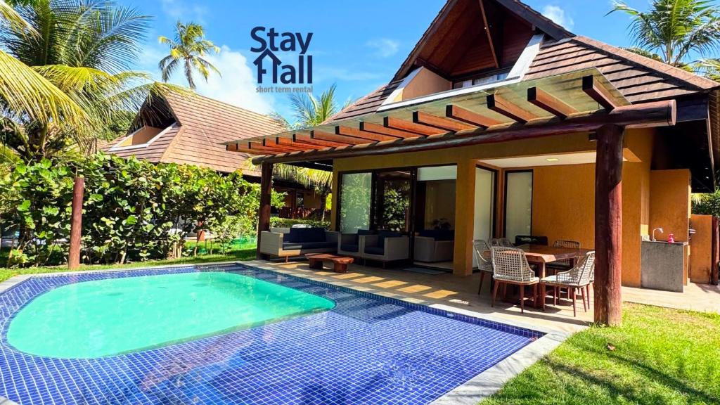 a villa with a swimming pool in front of a house at Bangalô na 3ª Fila c/ Piscina em Carneiros – SH022 in Praia dos Carneiros