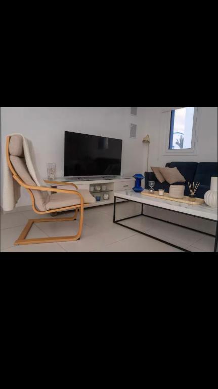 a living room with a chair and a tv at MERAKI Villa in Paralimni