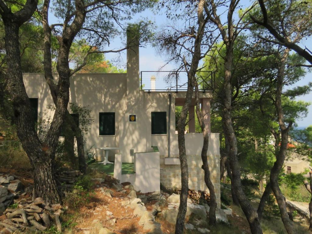 a house with trees in front of it at House Holiday Lodge in Žirje