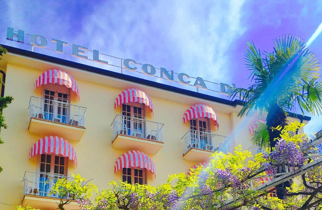 a building with red and white a hotel at Hotel Conca D'Oro ***S in Garda