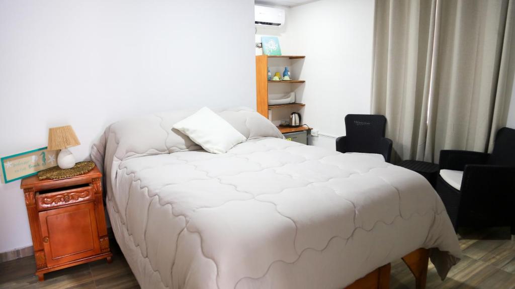 a bedroom with a large white bed and a table at Coconut beach lodge in San Andrés