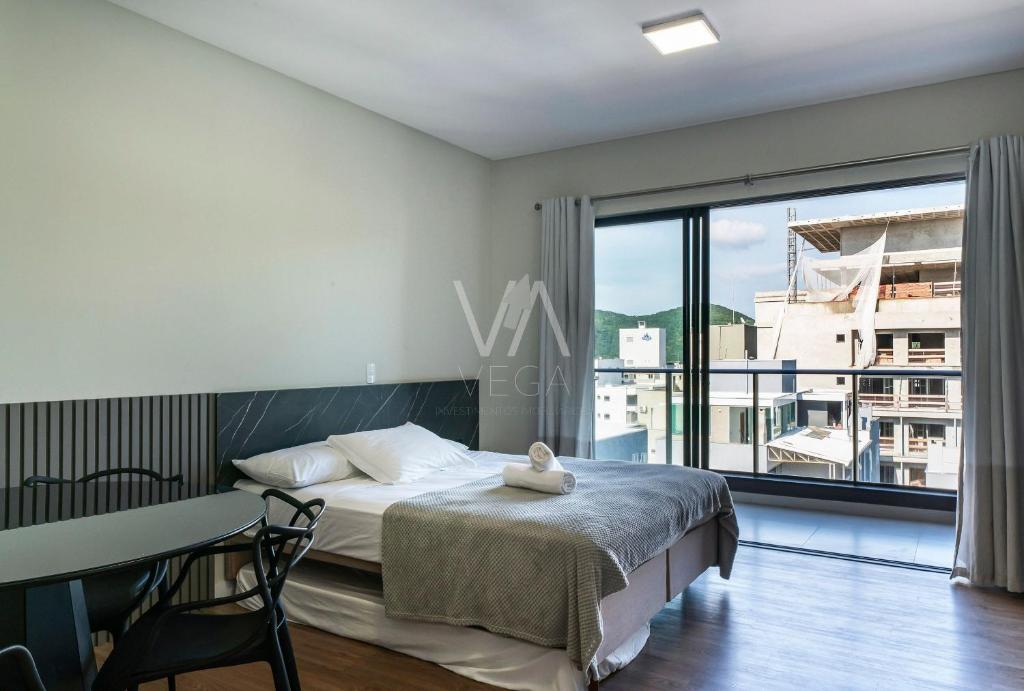 ボンバスにある509- Suite no Villa Francione Bombasのベッドと机と大きな窓のある寝室