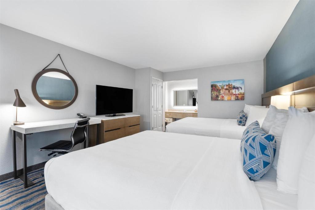ein Hotelzimmer mit zwei Betten und einem Schreibtisch in der Unterkunft Best Western San Diego&#47;Miramar Hotel in Miramar