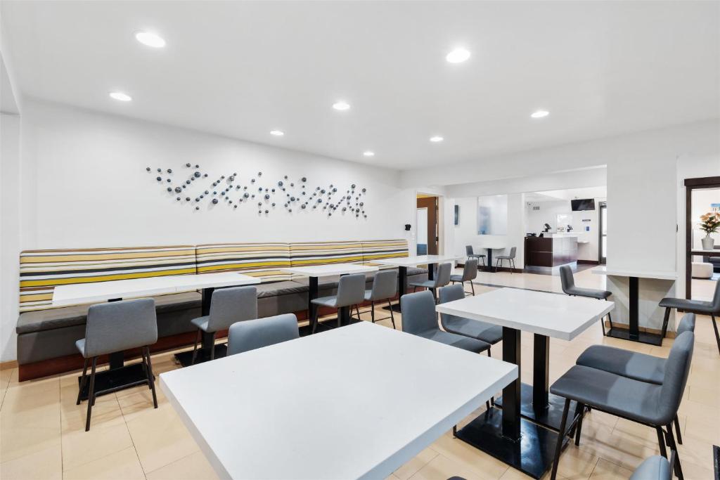 ein Esszimmer mit weißen Tischen und Stühlen in der Unterkunft Best Western San Diego&#47;Miramar Hotel in Miramar