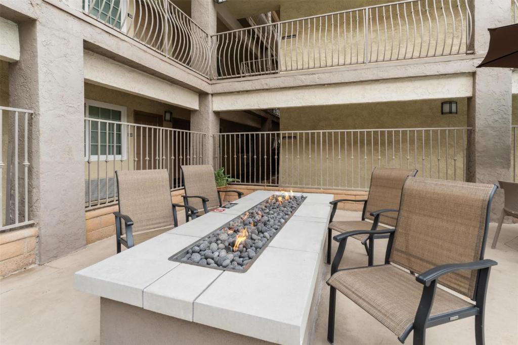 eine Terrasse mit einem Tisch mit Stühlen und einem Kamin in der Unterkunft Best Western San Diego&#47;Miramar Hotel in Miramar