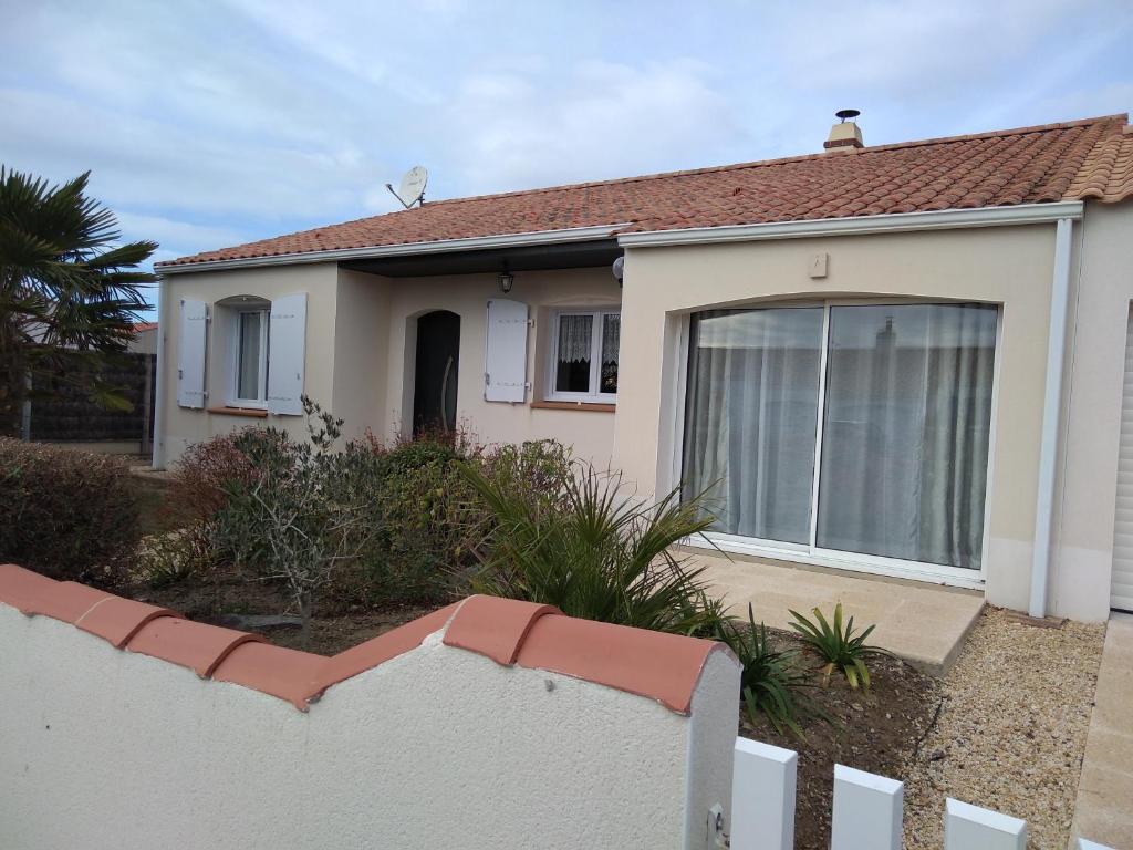 une maison avec une clôture blanche devant elle dans l'établissement La Petite Pépite, à Saint-Hilaire-de-Riez