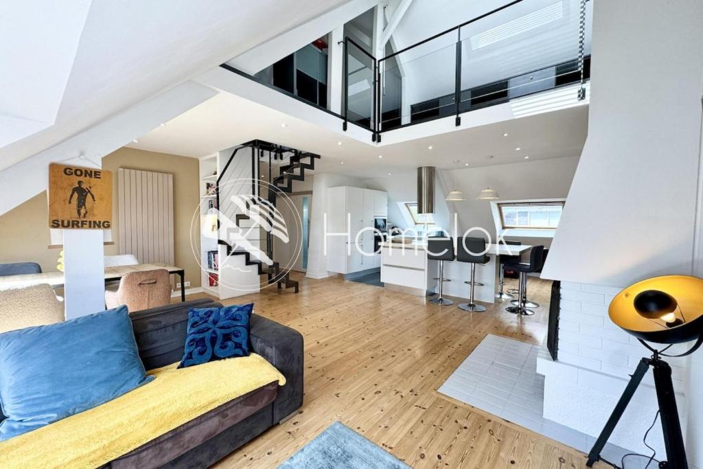 ein Wohnzimmer mit Couch und ein Esszimmer in der Unterkunft Loft contemporain - En plein centre de Lorient in Lorient