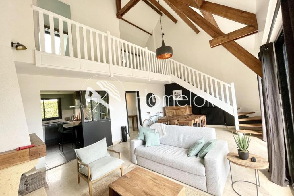 - un salon avec un canapé blanc et un escalier dans l'établissement Maison de charme - Proche plages et bourg, à Larmor-Plage