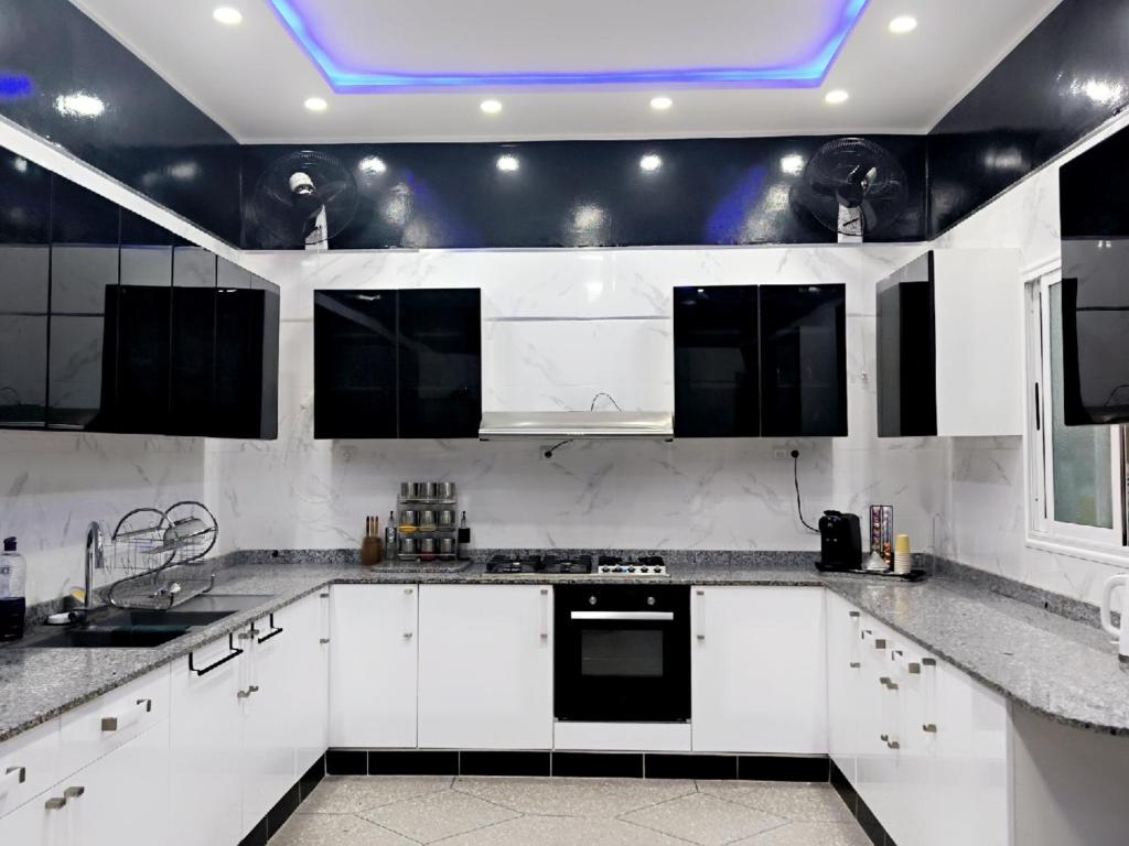a kitchen with white cabinets and a blue ceiling at Home Amazigh Serenity in Tinerhir