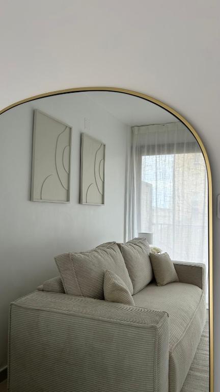 un salon avec un grand miroir au-dessus d'un canapé dans l'établissement Studio à 50 m de la plage, à Canet