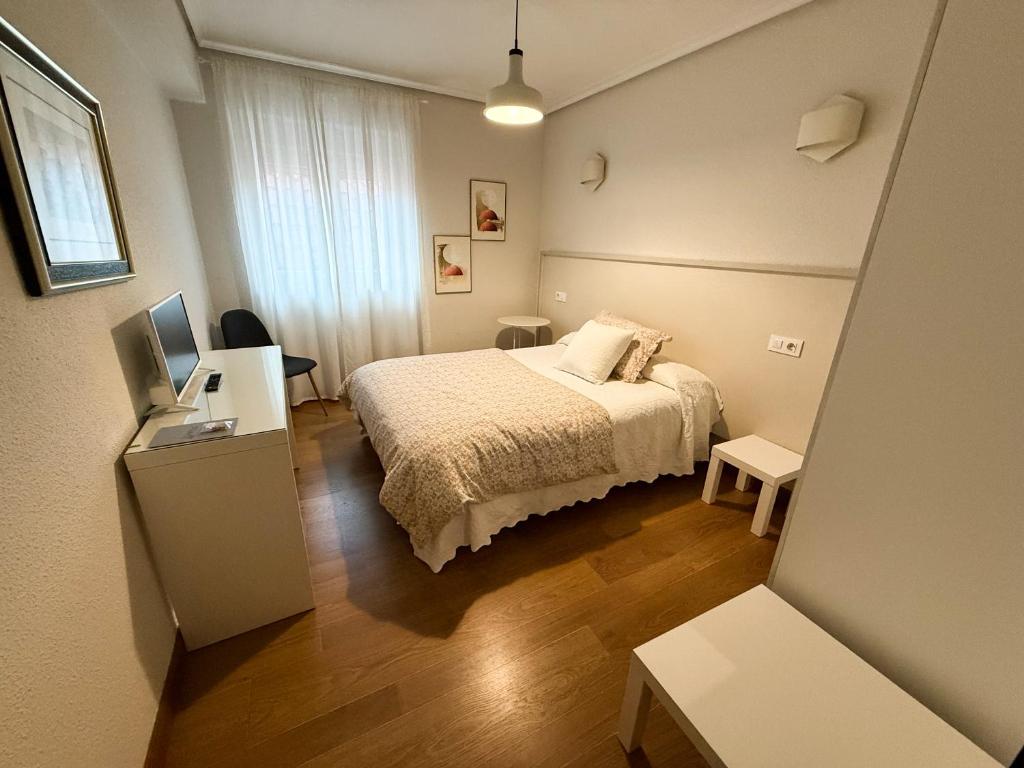 Dormitorio pequeño con cama y TV en Hostería El Cruce, en Cabezón de la Sal