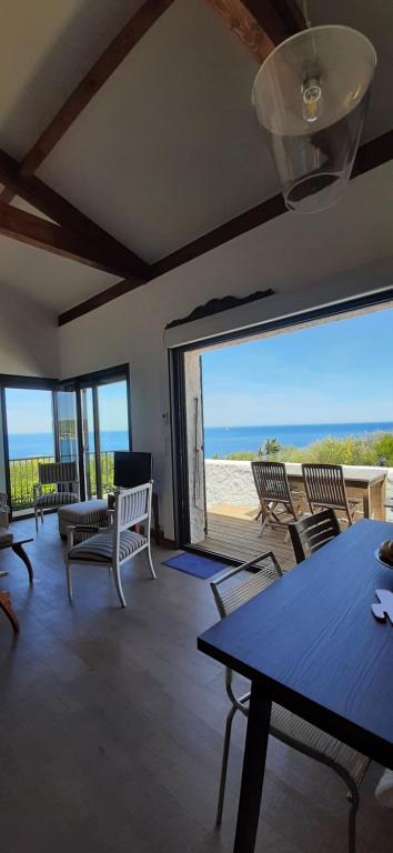 a living room with tables and chairs and a view of the beach at Villa Troc Pinell in Banyuls-sur-Mer