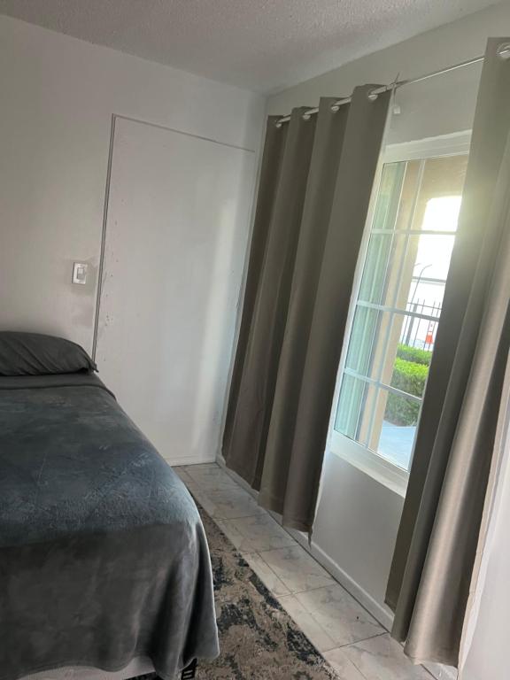 a bedroom with a bed and a window with curtains at Relaxing Studio in Los Angeles