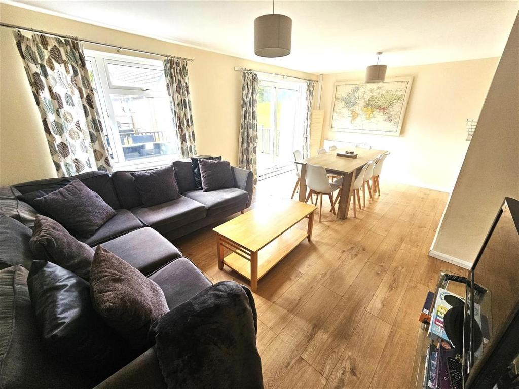 a living room with a couch and a table at Cosy detached lodge, dog & child friendly with shared pools in Gunnislake