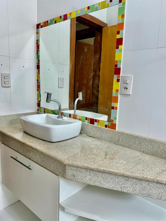 a bathroom with a sink and a mirror at Casa lazer Atafona in São João da Barra