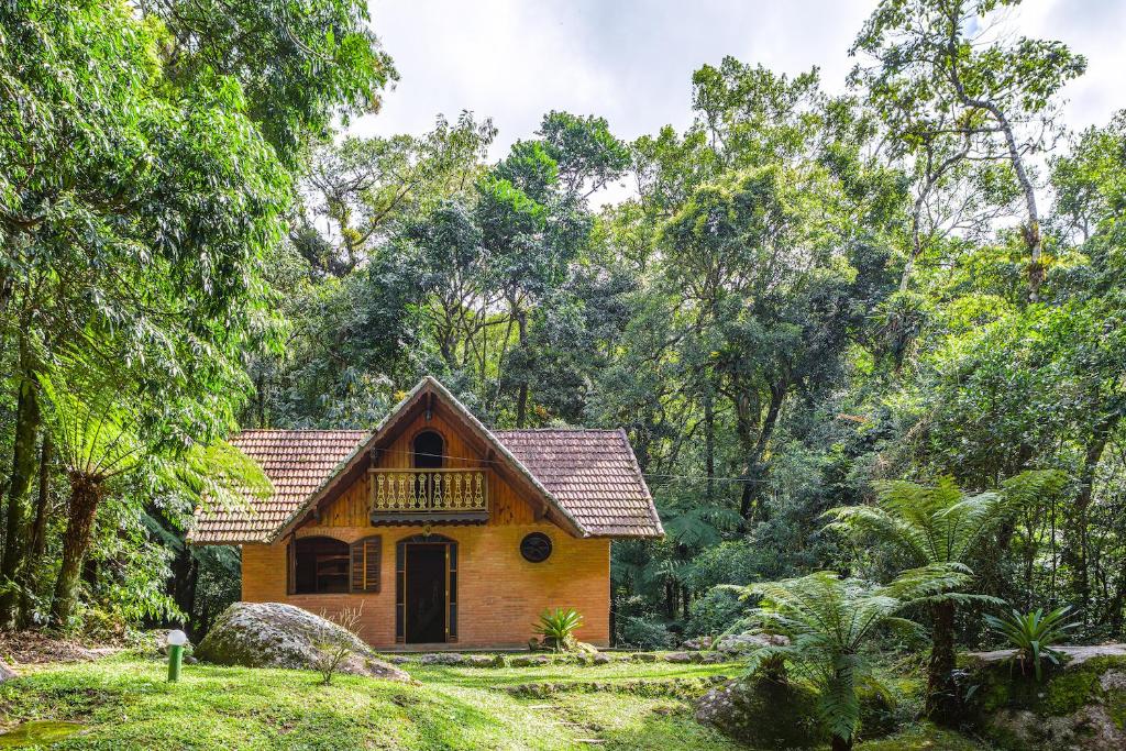 a small house in the middle of a forest at Estalagem Spiller in Monte Verde