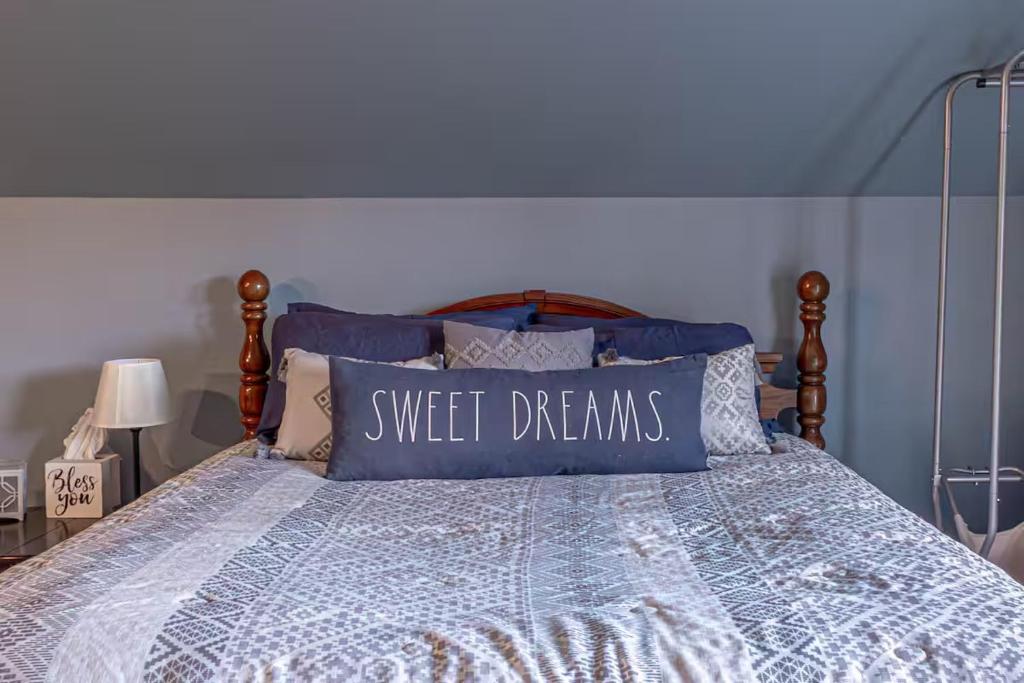 a bed with a pillow with the words sweet dreams on it at Over Garage Apartment Studio in Lincolnton