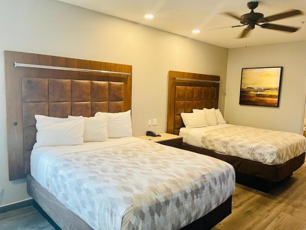 Una habitación de hotel con dos camas y un ventilador de techo. en Americas Best Value Inn La Porte, en La Porte