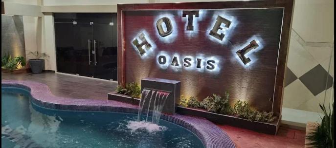 a sign for a hotel with a swimming pool at Hotel Oasis in Riberalta