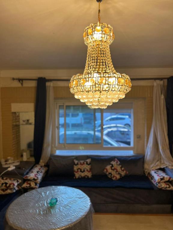 MARINA Agadir flat في أغادير: ثريا وطاولة في غرفة المعيشة