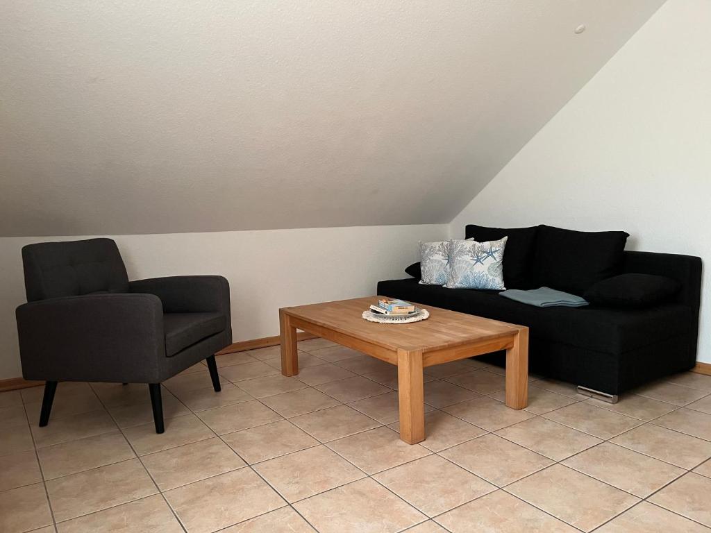 ein Wohnzimmer mit zwei Stühlen und einem Couchtisch in der Unterkunft Ferienwohnung Krabbe 2, Bensersiel, mit gemeinschaftlichen Garten in Holtgast