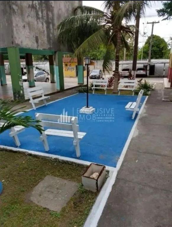 a blue swimming pool with two white benches on it at Ap COP 30 in Ananindeua