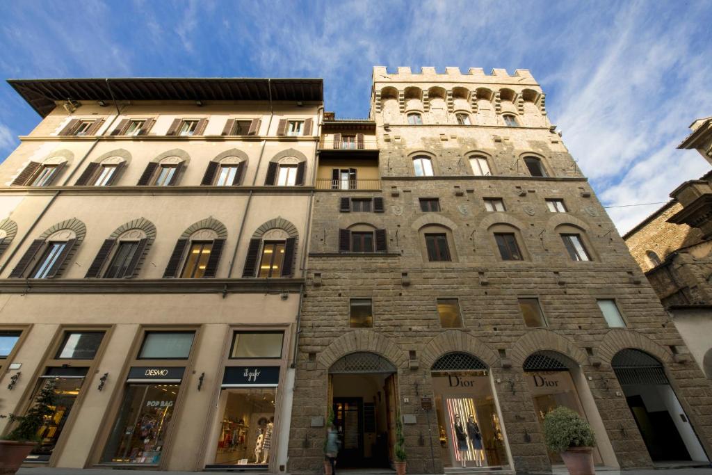 een hoog bakstenen gebouw met een klokkentoren bij Antica Torre Di Via Tornabuoni 1 in Florence