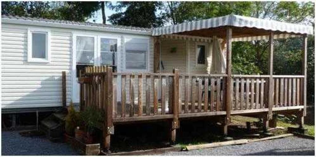 a house with a wooden deck with a gazebo at Camping 3 étoiles - Piscine - cca0gbb in Apremont