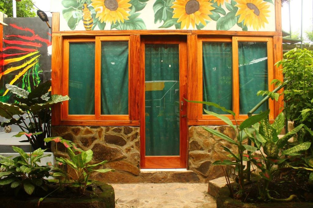 a window in a room with flowers on the wall at Lazy Crab Hostel in Balgue