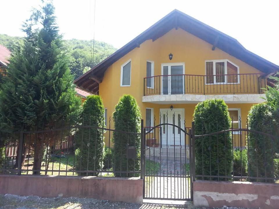 a yellow house with a fence and trees at Casa Brad Sovata in Sovata