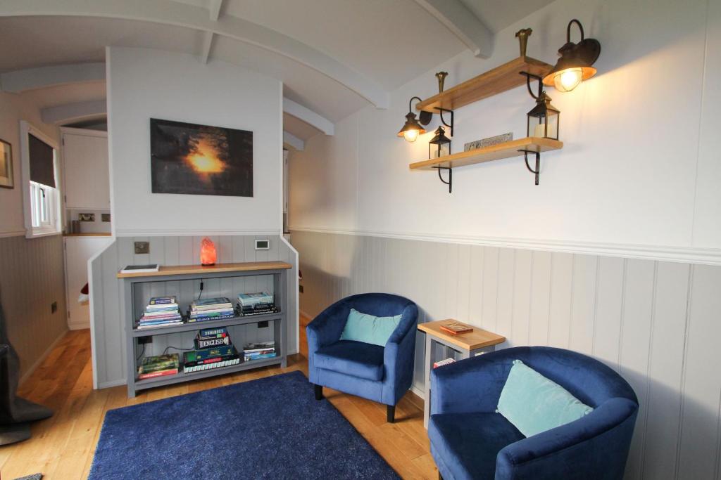 ein Wohnzimmer mit 2 blauen Stühlen und einem Tisch in der Unterkunft Isabel Top Farm in Marsham