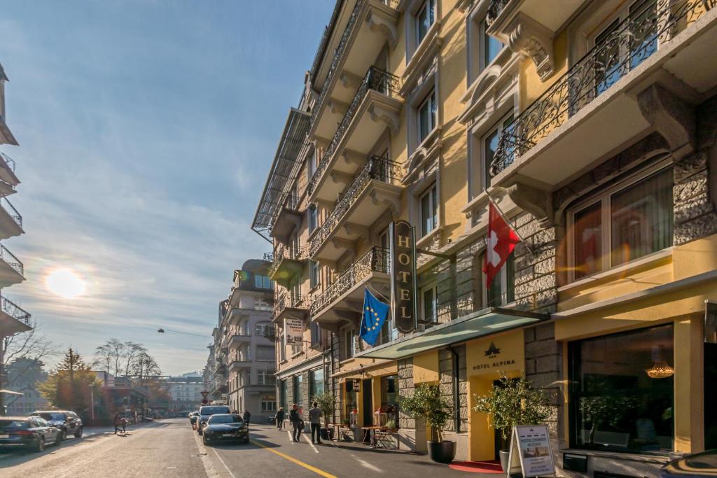 una calle de la ciudad con edificios y coches aparcados en la calle en Hotel Alpina Luzern, en Lucerna