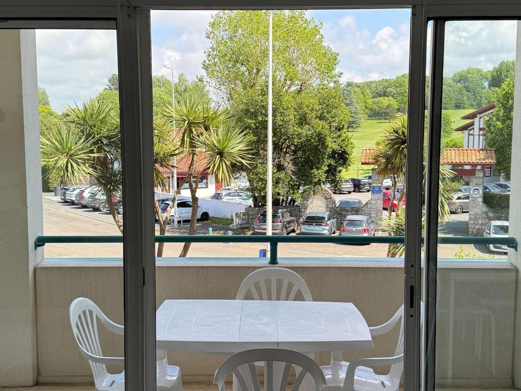 d'une table et de chaises sur un balcon avec vue sur le parking. dans l'établissement Studio face au golf avec terrasse et parking - FR-1-4-702, à Ciboure