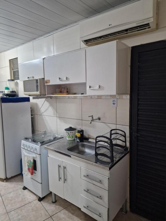 a kitchen with a sink and a stove and a refrigerator at FLAT CENTRAL- Ar-Condicionado-Estacionamento in Feira de Santana