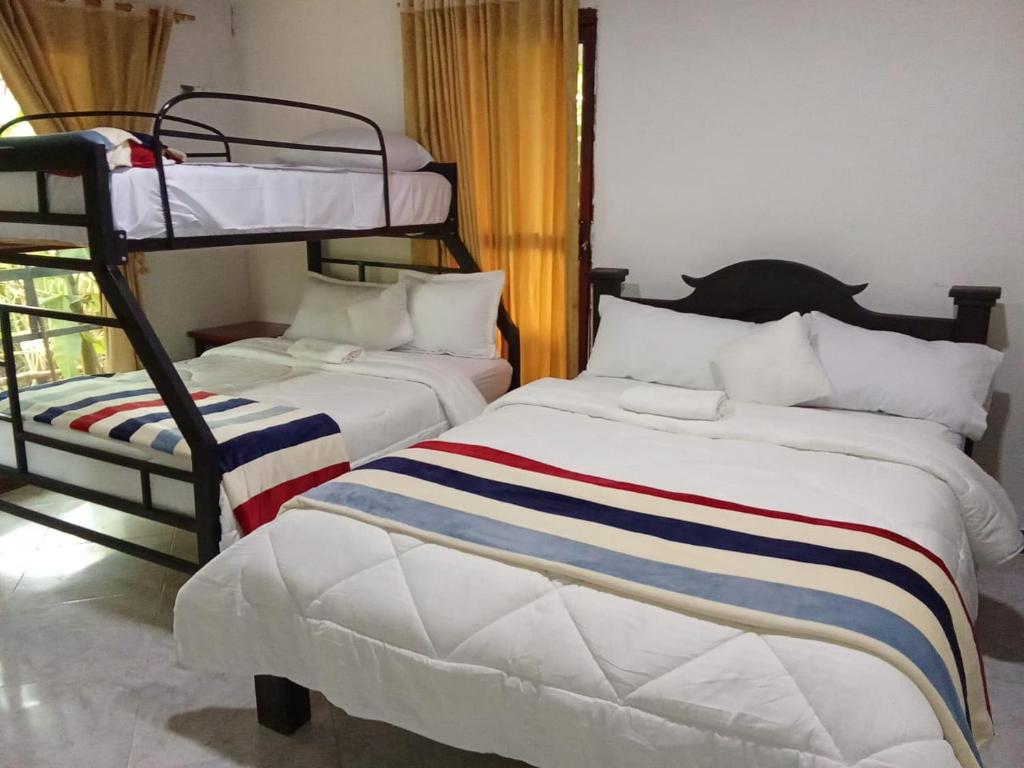 Rúm í herbergi á Curitagua Hotel Campestre