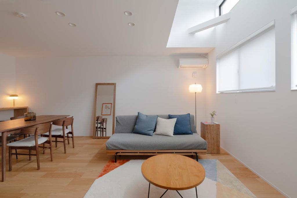 a living room with a couch and a table at LIRI 葵 3min to JR弁天町 Direct to USJ & Umeda & EXPO in Osaka