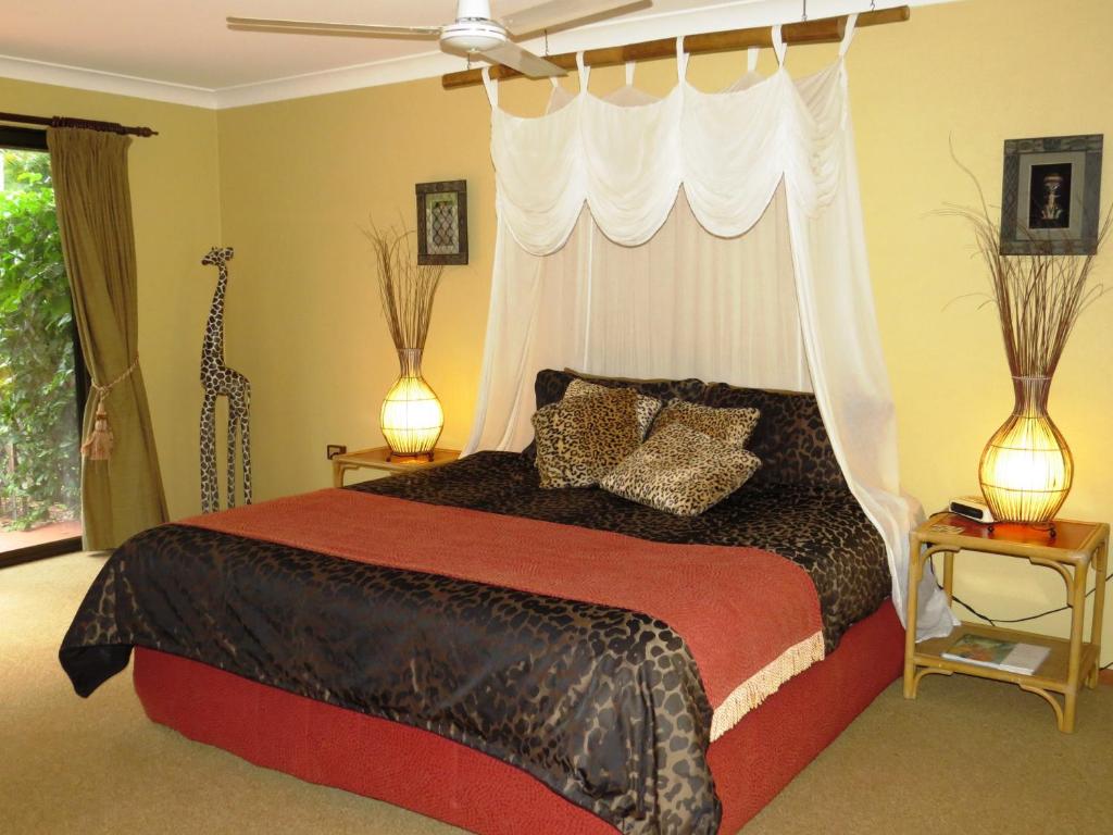 a bedroom with a large bed with a canopy at Gumtree on Gillies Bed and Breakfast in Yungaburra