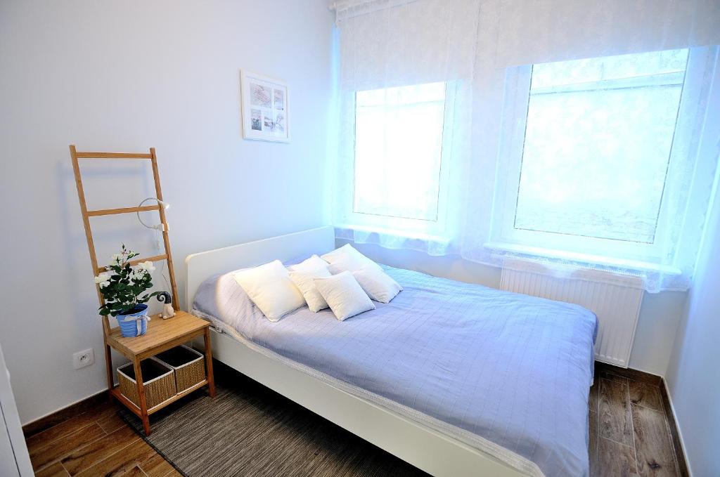 ソポトにあるVictus Apartamenty, Apartament Askjaのベッドルーム1室(枕2つ、窓2つ付)