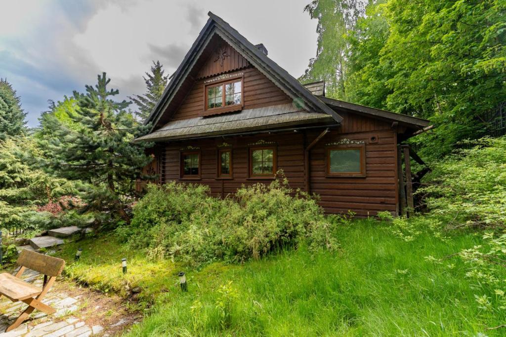 a small wooden house in the middle of a field at Domek Góralski przyjazny zwierzętom - ogrodzony - Blisko szlaków i aquaparku - z prywatną sauną, ogrodem in Karpacz