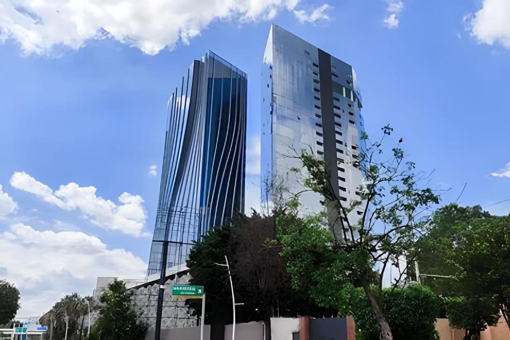 Dos altos edificios de cristal en una calle de la ciudad en Parklife Pabellón, en Guadalajara