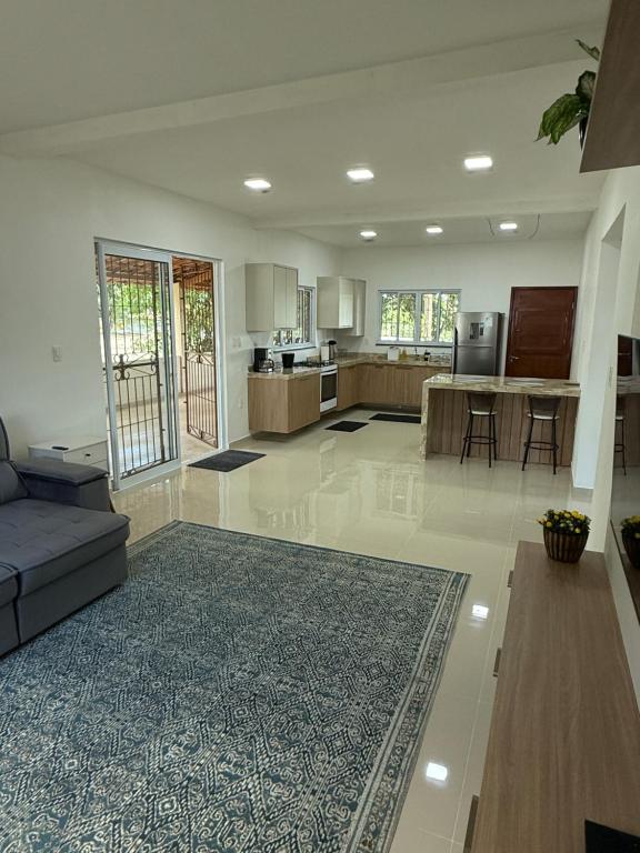 ein großes Wohnzimmer mit Couch und Küche in der Unterkunft Malicia Ranch in Lagoa do Boi