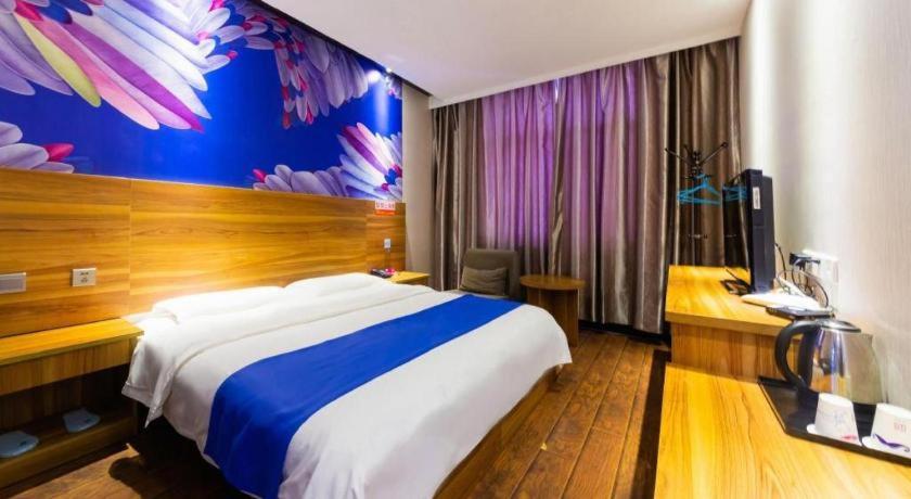 een hotelkamer met een groot bed en een bureau bij PAI Hotel Huayin Huashan Mountain Scenic Spot Ancient Street in Huayin