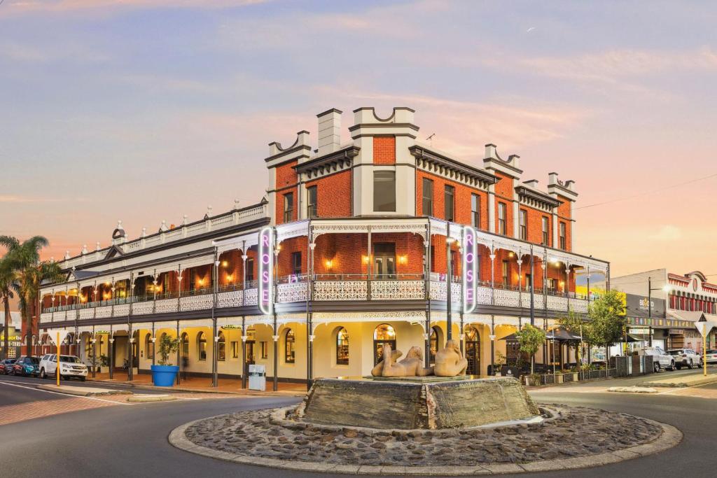 Un gran edificio con una fuente delante. en The Rose Hotel &amp; Motel, en Bunbury