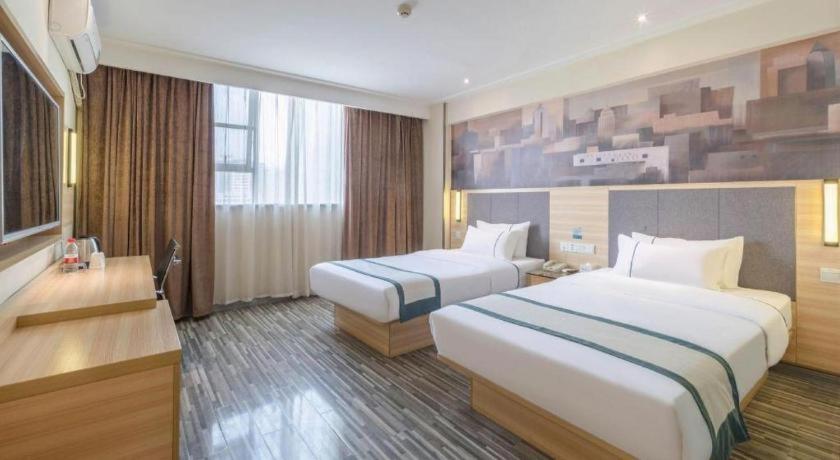 ein Hotelzimmer mit zwei Betten und einem Schreibtisch in der Unterkunft City Comfort Inn Liuzhou The Mixc Xijiang Road in Liuzhou