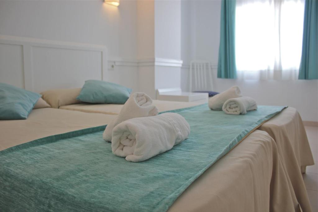 a bed with two towels on top of it at Hostal Brisa Marina in Port d'Alcudia